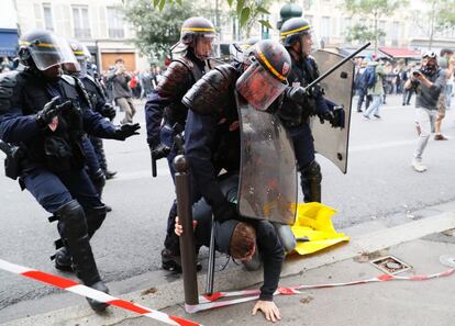 Policias antidisturbios, recubiertos de pintura roja, detienen a un hombre durante la manifestación contra la reforma laboral del gobierno francés, en París.