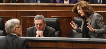 Soraya Sáenz de Santamaría dialoga con el portavoz económico de CiU, Josep Sánchez Llibre, en presencia del ministro de Justicia, Alberto Ruiz-Gallardón.