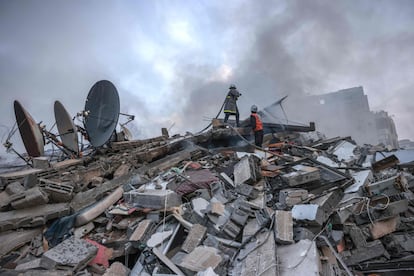 Dos bomberos trabajaban este domingo entre los escombros de un edificio bombardeado por el Ejército israelí en Gaza. 