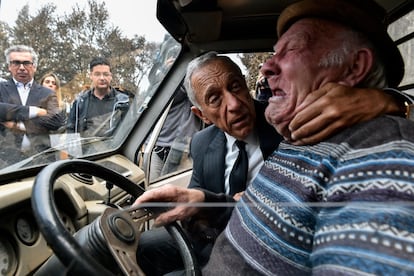 El presidente luso, Marcelo Rebelo de Sousa, consuela a un hombre mientras llora, durante una visita a los municipios del centro del país afectados por los incendios forestales de la semana pasada, en Santa Comba, Vouzela (Portugal).