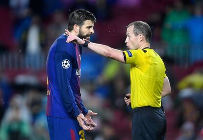 Gerard Piqué del Barcelona recibe tarjeta amarilla del arbitro William Collum.