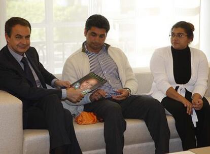 El presidente Zapatero muestra la imagen de la niña Mari Luz durante la reunión de ayer con sus padres.