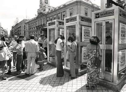 Un grupo de personas espera para llamar por teléfono en la Puerta del Sol en 1978