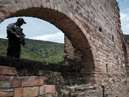 A member of Colombia’s Special Security Task Force stands guard near the ruins of a crematorium in Juan Frío, on May 9, 2023.