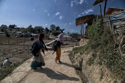 Jóvenes rohingya corretean al salir de la escuela, a través de campos de la población local en los alrededores del campo de refugiados de Jamtoli.