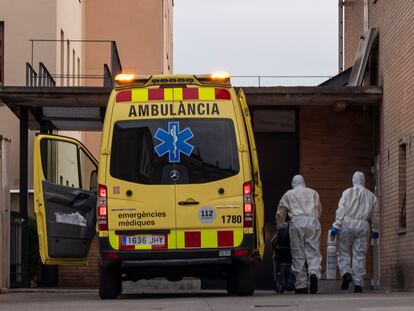 Dos miembros del personal sanitario, equipados con trajes protectores, se disponen a trasladar a un abuelo de la residencia de Tremp al hospital.