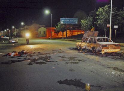 Un cadáver al lado de un coche incendiado en Urumqi tras la violenta represión de la protesta uigur el pasado domingo.