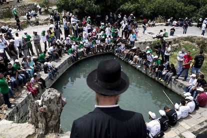 Un judío ultraortodoxo observa a varios palestinos protestar en la aldea de Lifta, (noroeste de Jerusalén, Israel), durante las celebraciones de la "nakbat" o desastre, como los árabes denominan la fundación del Estado de Israel, que rememora la firma en 1948 de un pacto que escindió en dos la Palestina histórica y propició la expulsión de más de 750.000 palestinos.