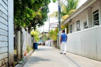 Troy Bodden, alcalde de Utila, camina por la calle Holland, la primera de Honduras pavimentada con asfalto hecho con plástico reciclado.