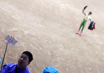 Un asistente a la corrida sin sangre de Moralzarzal se hace un selfi mientras el novillero saluda al público tras su actuación. Los visitantes chinos no han parado de hacer foto durante la faena.