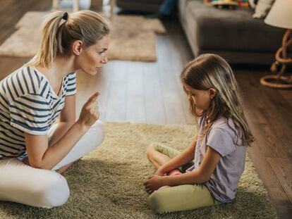 Una madre habla con su hija en el salón. 