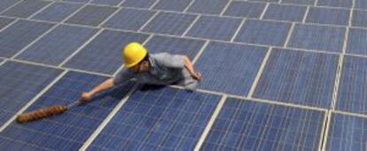Un trabajador limpia paneles solares.