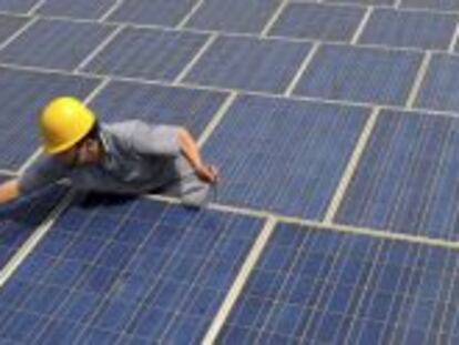Un trabajador limpia paneles solares.
