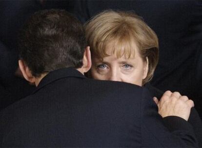 Angela Merkel recibe un abrazo de Nicolas Sarkozy.