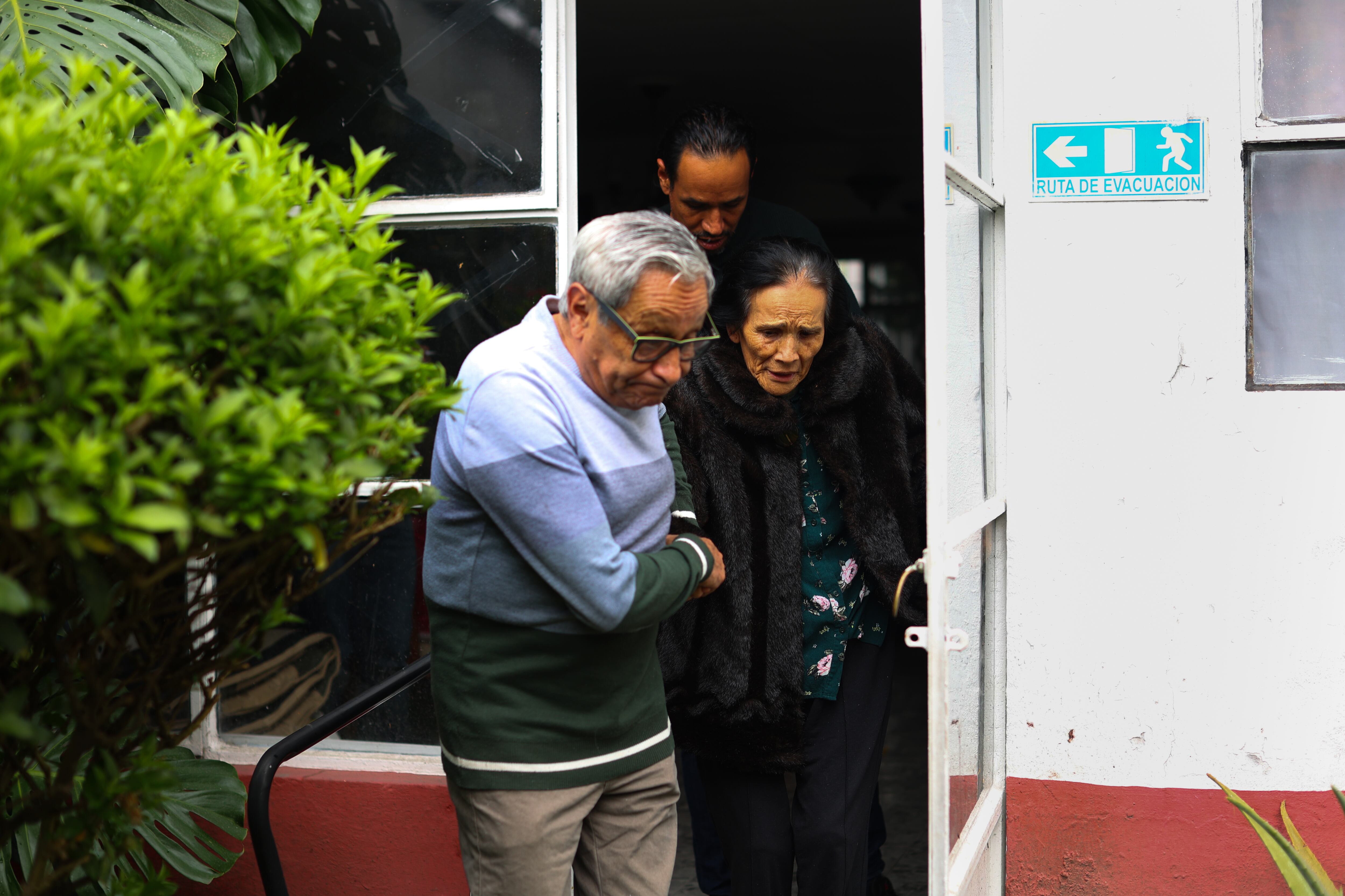 El esposo y el hijo de Sabogal la acompañan al salir de su residencia de ancianos.