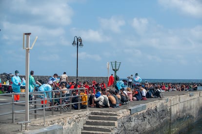 Decenas de inmigrantes son atendidos en el muelle tras llegar a Órzola (Lanzarote), este domingo.