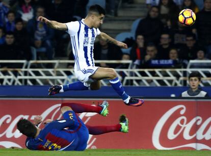 El defensa de la Real Sociedad Yuri Berchiche (arriba) supera al defensa del FC Barcelona Gerard piqué (suelo).