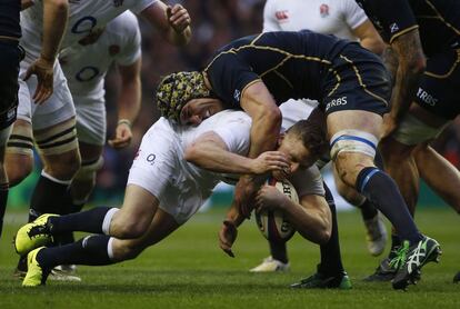 Chris Ashton de Inglaterra es placado por el jugador de Escocia Kelly Brown.