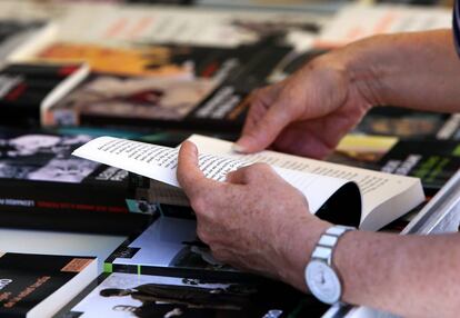 Un hombre hojea un libro en la Feria del Libro de Madrid 2017, en el Parque del Retiro.