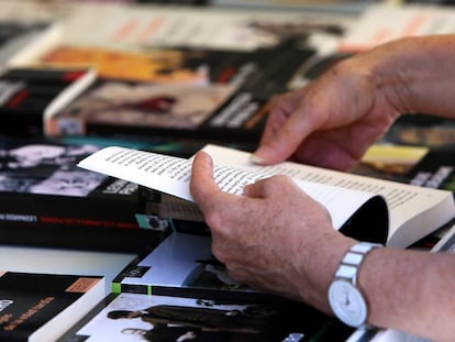 Un hombre hojea un libro en la Feria del Libro de Madrid 2017, en el Parque del Retiro.