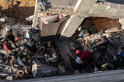 Los vecinos de un barrio de Rafah buscan supervivientes entre los escombros de un edificio bombardeado por Israel este jueves.