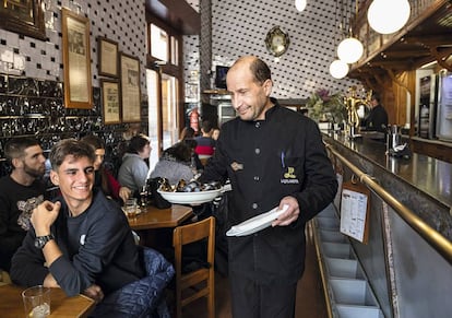 Un camarero del bar La Pilareta, en Valencia, sirve una ración de clòtxines.