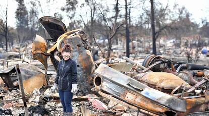 Una mujer anda entre los escombros tras el incendio en California.