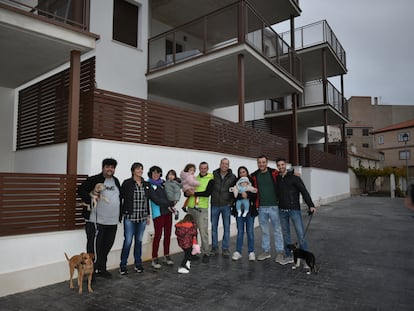 Algunos de los nuevos vecinos de Letur (Albacete) junto a los pisos donde viven.