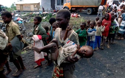 Un niño traslada en brazos a otro menor, desfallecido, a su llegada a un orfanato cerca de Goma, antiguo Zaire, el 19 de julio de 1994.