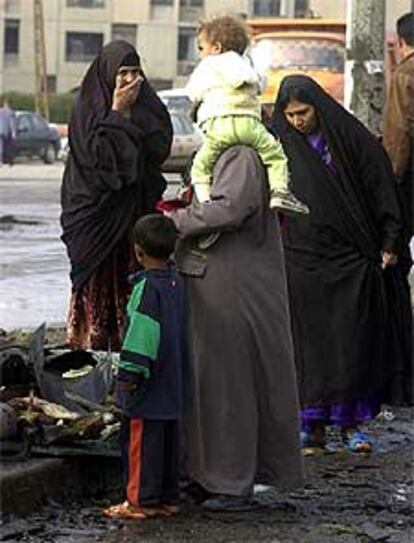 Varias mujeres iraquíes observan los destrozos ocasionados por la explosión en Bagdad.