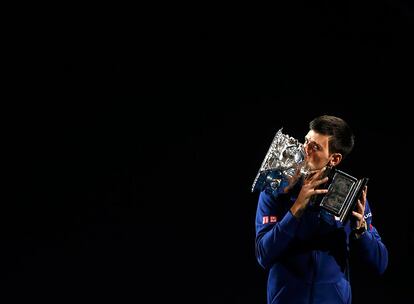 O tenista sérvio, Novak Djokovic, beija seu troféu depois de ganhar o Aberto da Austrália, em 31 de janeiro de 2016.