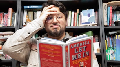 Felipe Torres Medina with a copy of his book 'America: Let Me In,' in his New York apartment in February 2025.