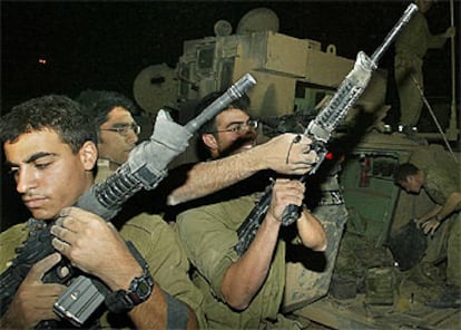Varios soldados israelíes comprueban sus armas durante la retirada, anoche, del norte de Gaza.