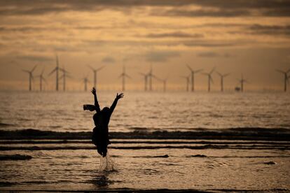 Una chica salta en la orilla de la playa de Crosby, Liverpool (Reino Unido). 