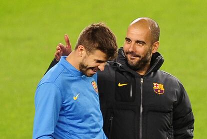 Pep Guardiola bromea con Piqué durante el entrenamiento de ayer en el Camp Nou.