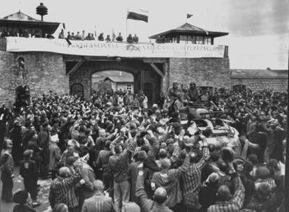 Prisioneros en Mauthausen reciben a las tropas que liberaron el campo en 1945. En la torre, una pancarta de los españoles.