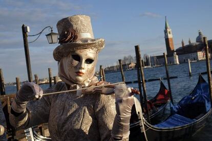 Un violinista disfrazado con un traje del siglo XVIII ensaya junto a la plaza de San Marcos de Venecia.