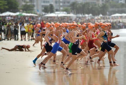 Atletas corren hacia el agua en el inico del triatlón en la playa de Copacabana.