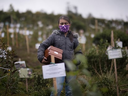 Una mujer porta una urna con cenizas de un familiar, muerto por complicaciones relacionadas con la covid-19 en la Reserva Natural El Pajonal de Cogua, al norte de Bogotá, Colombia.