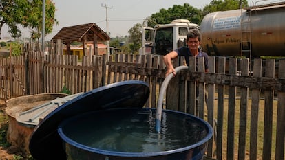 Freddy Salles, en Río Branco, lleva agua a la casa de una mujer que requiere hemodiálisis. Durante la temporada de sequía, la escasez de agua no solo provoca incendios y perjudica la agricultura, sino que también afecta a los vecinos que se quedan sin ella para uso doméstico.