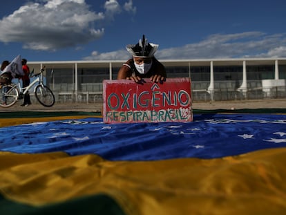 Um manifestante segura uma faixa que diz "Oxigênio respira Brasil" durante um protesto contra o presidente Jair Bolsonaro em Brasília.