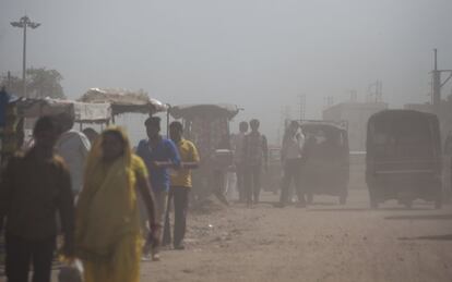 La gente camina a través del polvo en Nueva Delhi, India. Esta atmósfera contaminada dificulta la visión y hace a las personas vulnerables a enfermedades respiratorias.