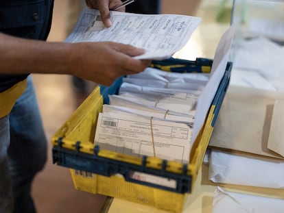 Un cartero entrega los votos por correo en una mesa electoral en Barcelona, este domingo.