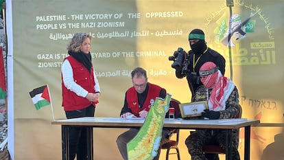 Miembros del Comité Internacional de la Cruz Roja (CICR) y miliciano de Hamás firman un protocolo como parte de los intercambios de rehenes israelíes y prisioneros palestinos, este jueves en Yabali, en el norte de Gaza.