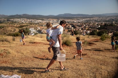 Una de las familias implicadas en el proyecto vecinal Operación Encina, en el momento de regar.