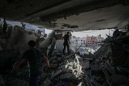 Varias personas buscan supervivientes en un edificio destruido tras un ataque israelí sobre Gaza.