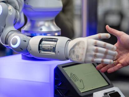 Una persona da la mano a un robot.