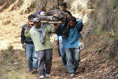Vecinos cargan el cuerpo de una víctima en Coxcaltlán.