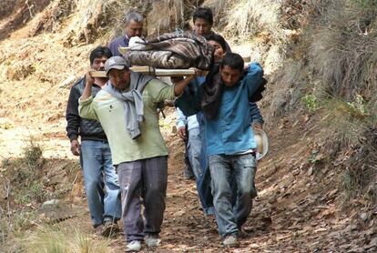 Vecinos cargan el cuerpo de una v&iacute;ctima en Coxcaltl&aacute;n.