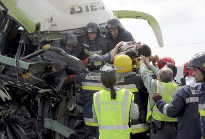 Los bomberos sacan a uno de los heridos del autobús accidentado ayer en Palencia.